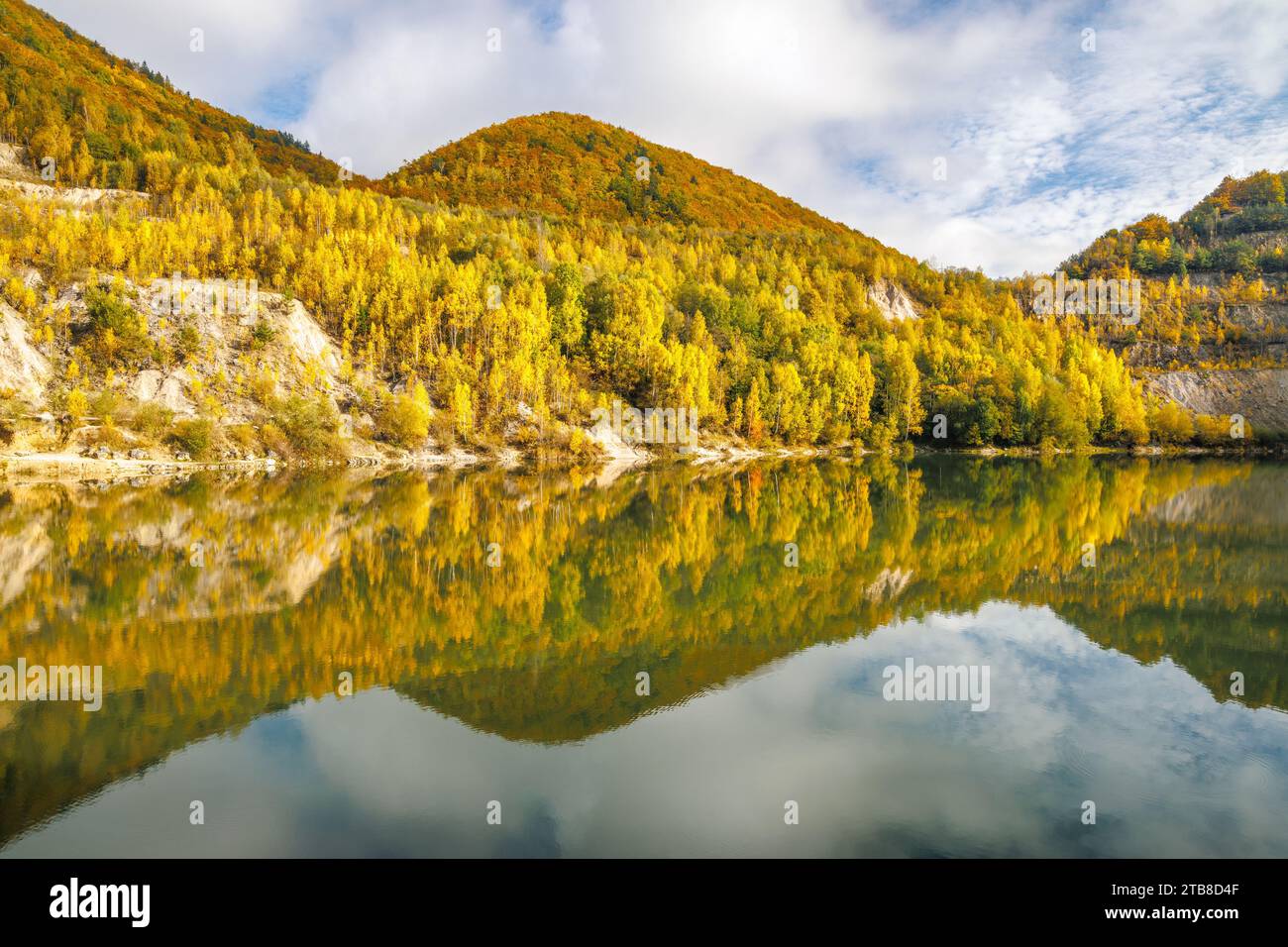 Autumn landscape with reflection of colorfull hills in the lake. Flooded quarry near the village Sutovo in Slovakia, Europe. Stock Photo