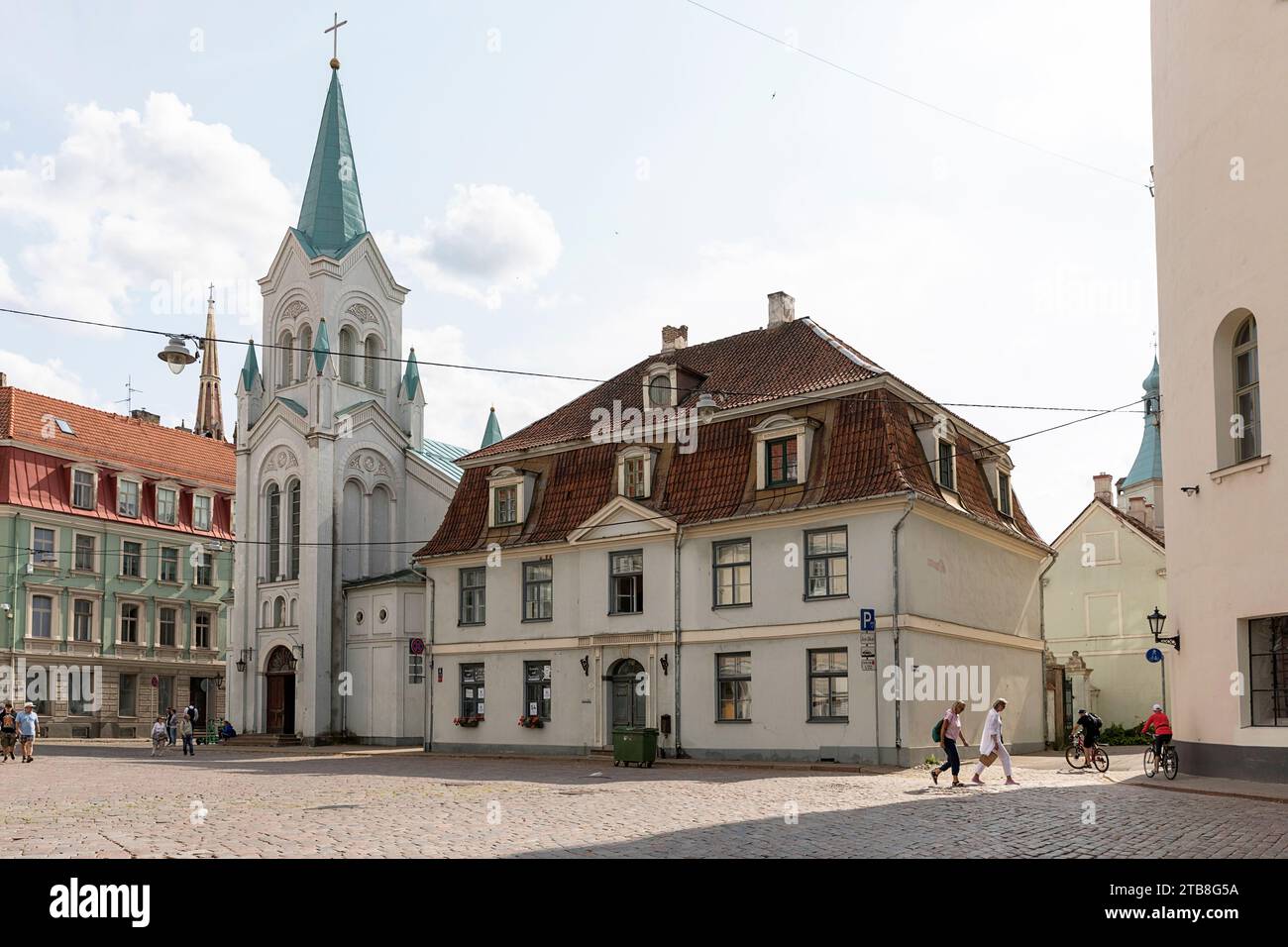 Tourists, locals, walking on a street in old part of Riga city in Latvia on a beautiful summer day Stock Photo