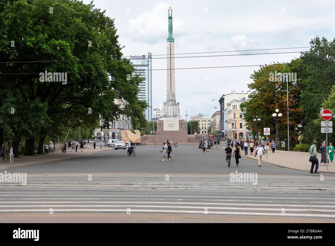 Locals and tourist walking on a road near The Freedom Monument on a beautiful summer day, Riga, Latvia Stock Photo