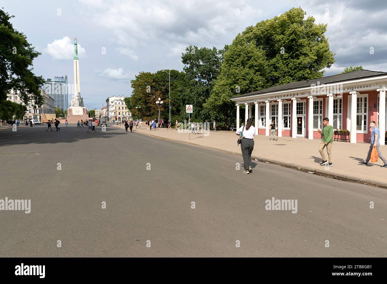 Locals and tourist walking on a road near The Freedom Monument on a beautiful summer day, Riga, Latvia Stock Photo