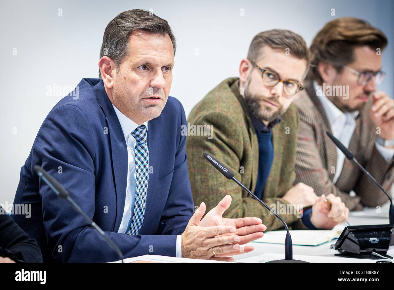 Hanover, Germany. 05th Dec, 2023. Olaf Lies (SPD, l), Minister of Economic Affairs of Lower Saxony, speaks at a press conference on the planned amendment to Lower Saxony's building regulations, sitting next to journalist Niklas Kleinwächter (M), Lower Saxony State Press Conference, and press spokesman Christian Budde (r), Lower Saxony Ministry of Economic Affairs, Transport, Building and Digitization. Credit: Moritz Frankenberg/dpa/Alamy Live News Stock Photo