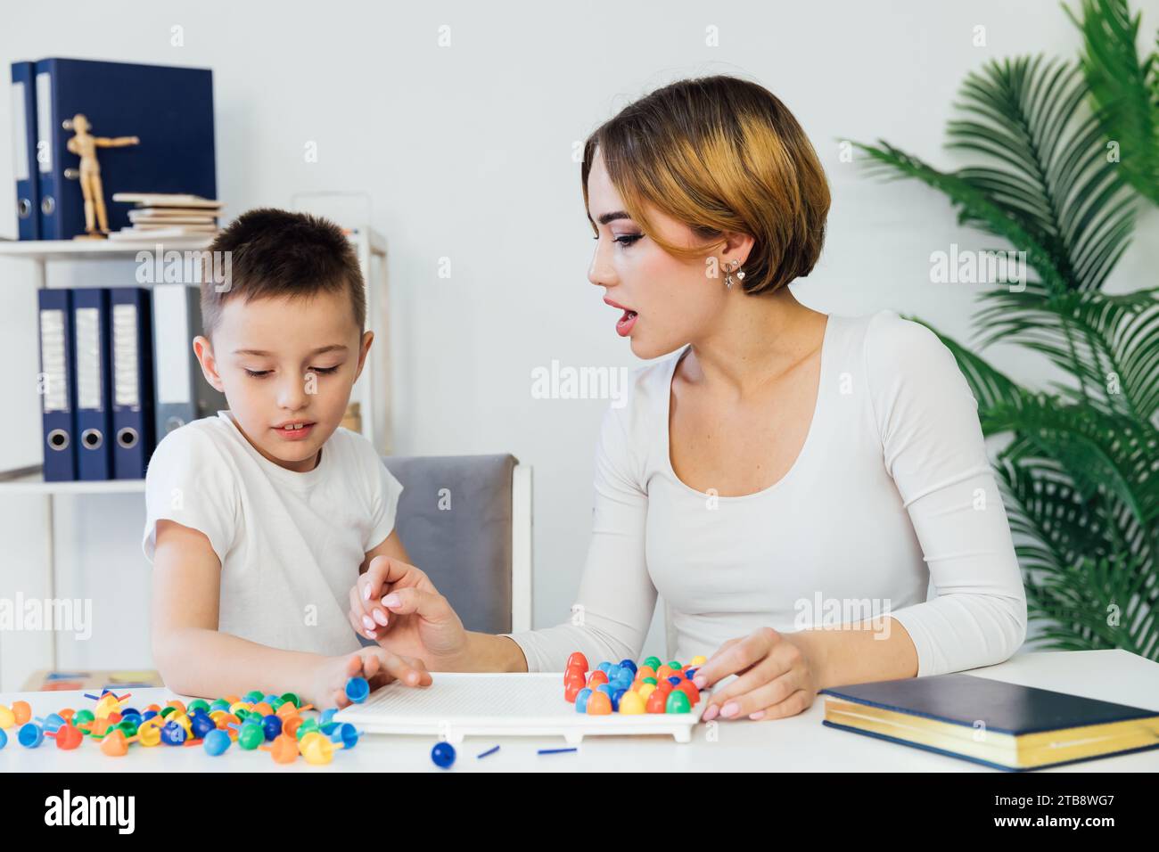 Female psychologist playing educational games with boy Stock Photo Alamy