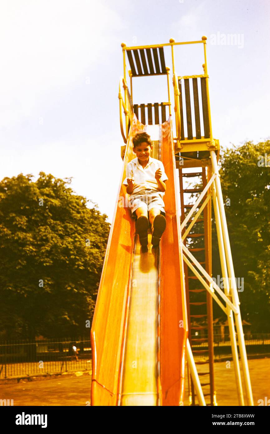 https://c8.alamy.com/comp/2TB8XWW/archival-slide-scan-young-boy-in-shorts-on-a-high-playground-slide-1960s-now-deemed-as-dangerous-2TB8XWW.jpg