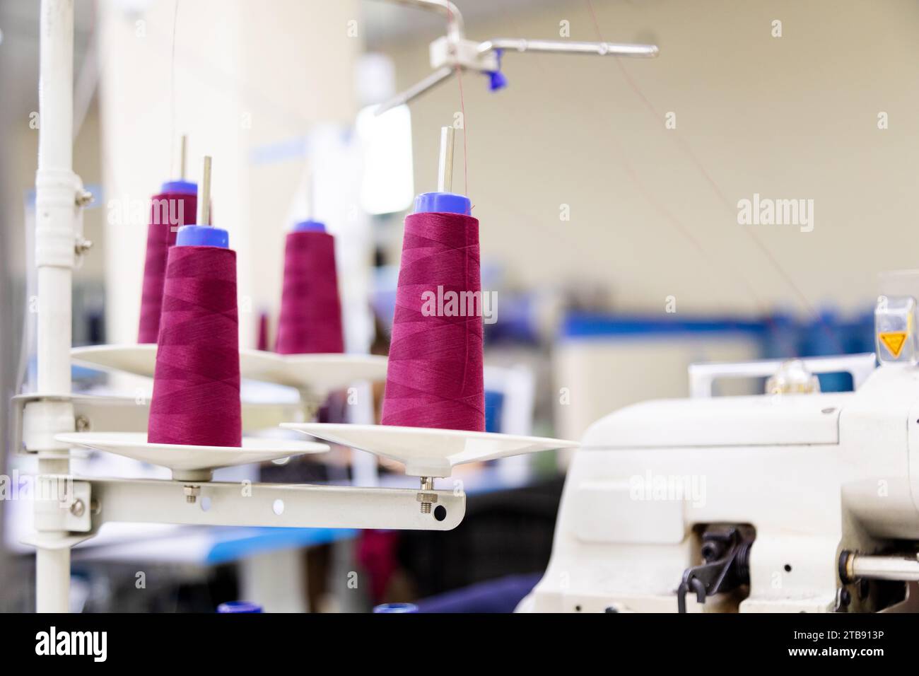 Close up of purple spool of sewing threads unrolling on sewing machine ...