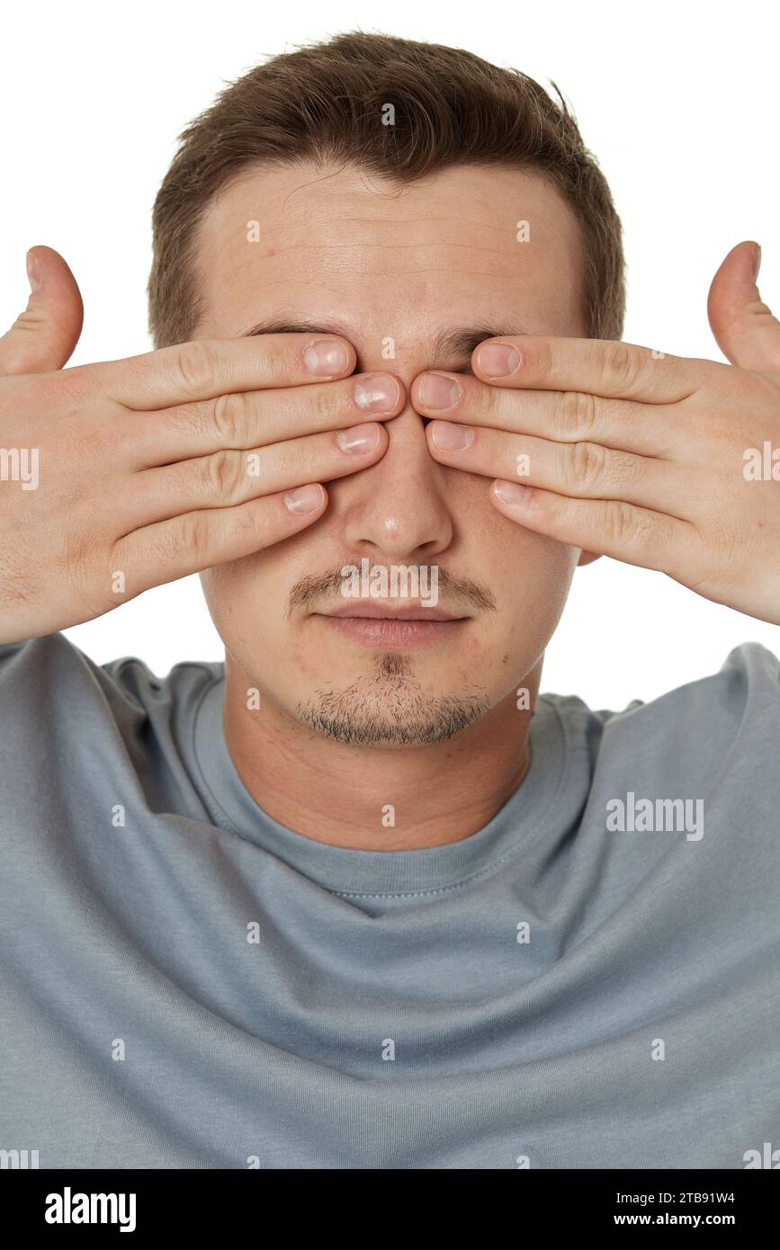 man covering eyes with hands on white background Stock Photo - Alamy