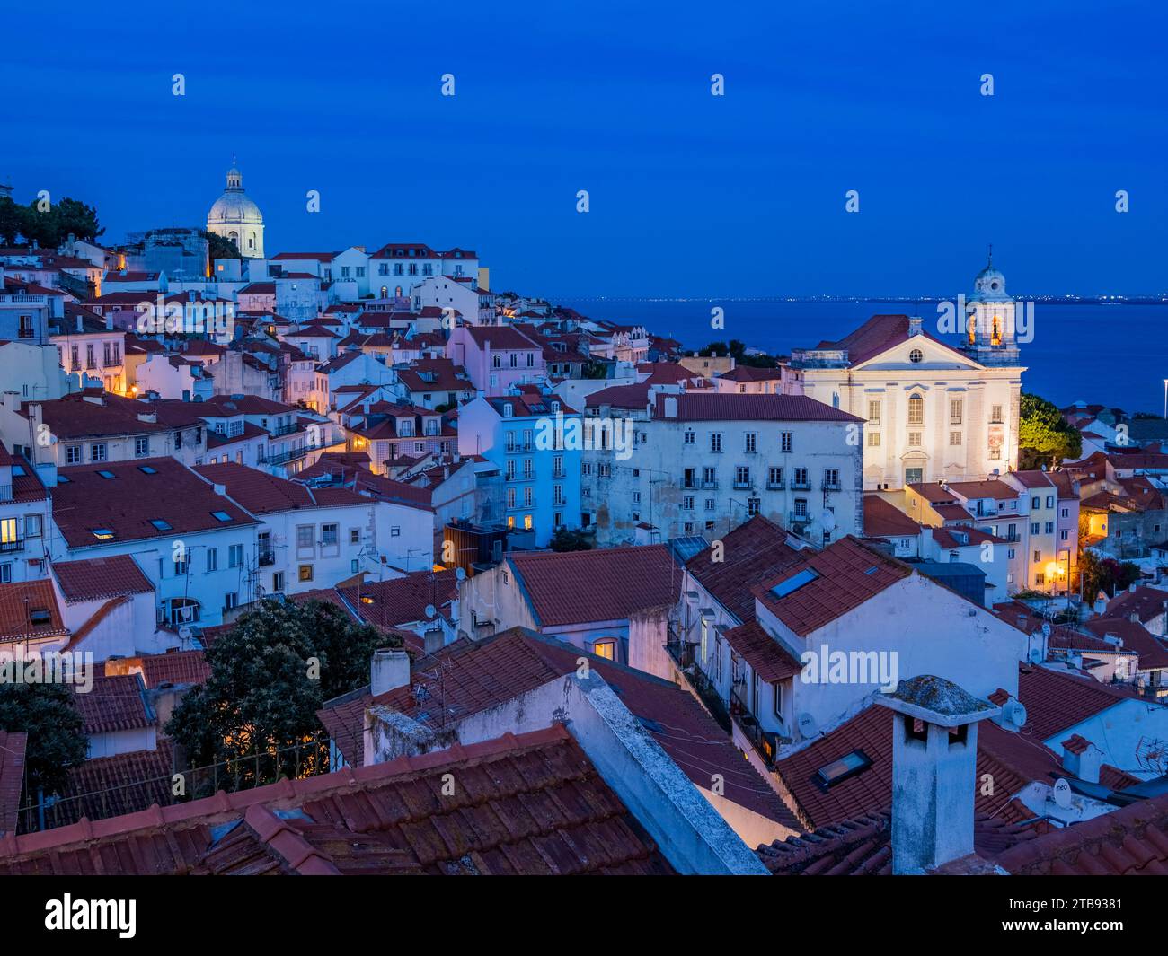 Santo Estevao church and the National Pantheon in the old town Alfama district  lit up at night from the Portas do Sol Viewpoint  in Lisbon Portugal Stock Photo