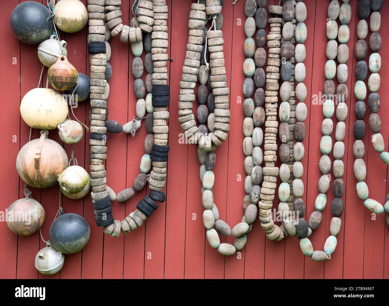 Fishing net floats and buoys hanging on the side of a building; Petersburg, Alaska, United States of America Stock Photo