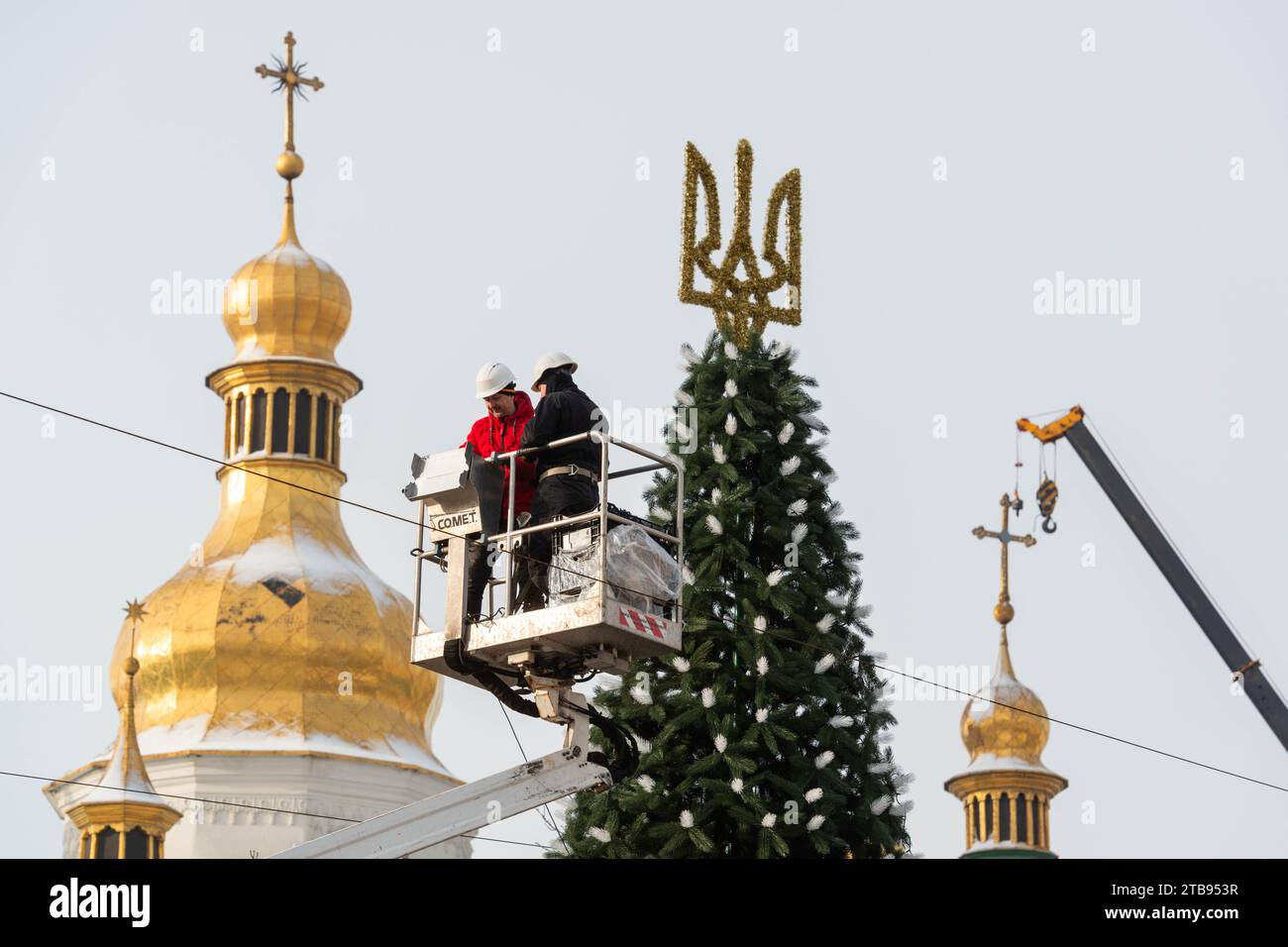 2023-12-05 Kyiv, Ukraine. Workers decorating the Christmas tree on the background of Sophia Cathedral domes. Stock Photo