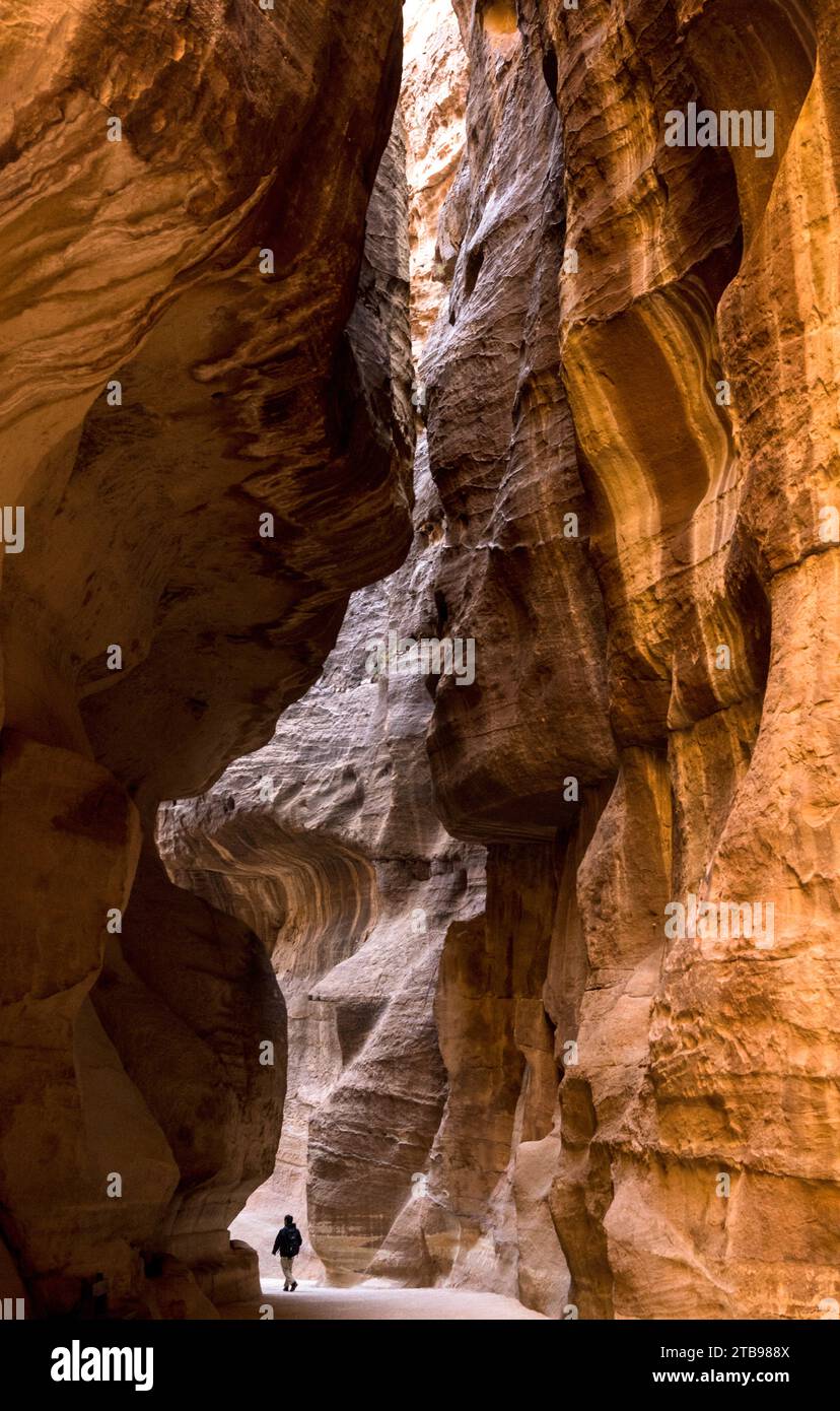 Person walking down the canyon to enter Petra; Petra, Jordan Stock Photo