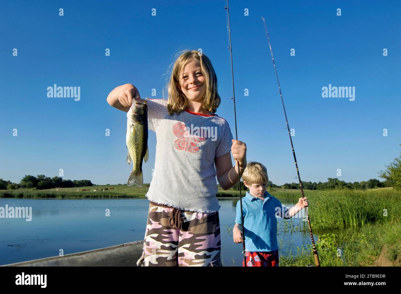 Young girl and her brother go bass fishing; Bennet, Nebraska, United States of America Stock Photo