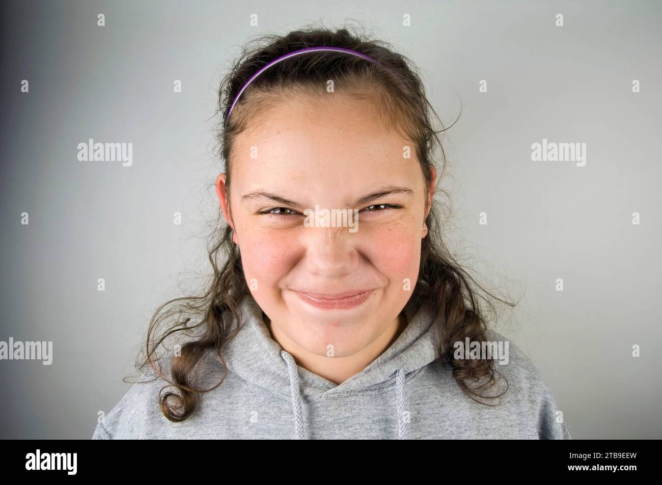 Portrait of a pre-adolescent girl making a funny face; Studio Stock Photo