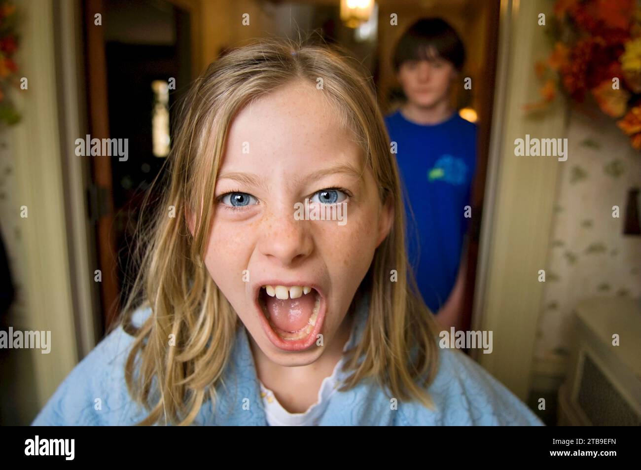 Girl shows her anger with her brother at home; Lincoln, Nebraska, United States of America Stock Photo