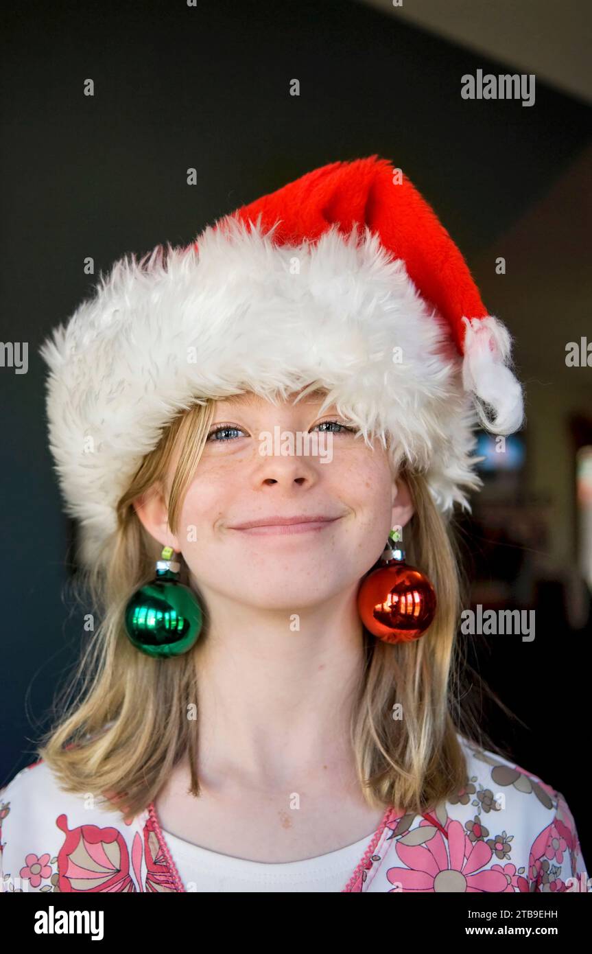 Girl plays with Christmas tree ornaments at home; Lincoln, Nebraska, United States of America Stock Photo