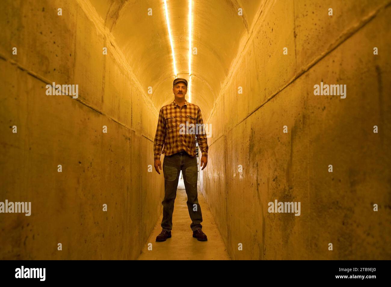 Man stands in a tunnel illuminated with light; Lincoln, Nebraska, United States of America Stock Photo