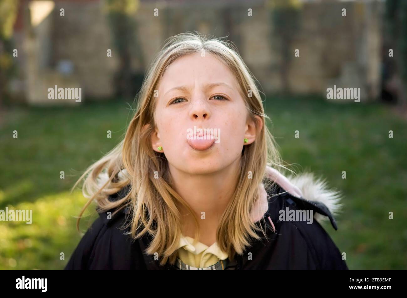 10-year-old girl sticks out her tongue at the camera; Lincoln, Nebraska, United States of America Stock Photo