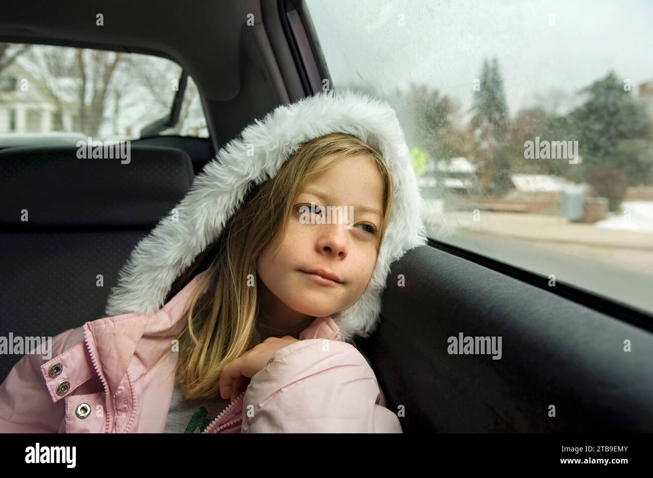 Young girl looks out the window during a car ride; Lincoln, Nebraska, United States of America Stock Photo