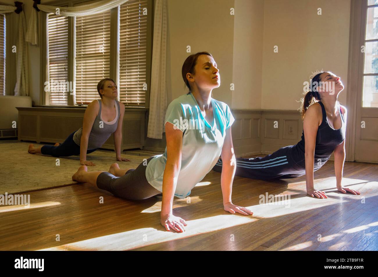 Three young woman practice yoga; Lincoln, Nebraska, United States of America Stock Photo