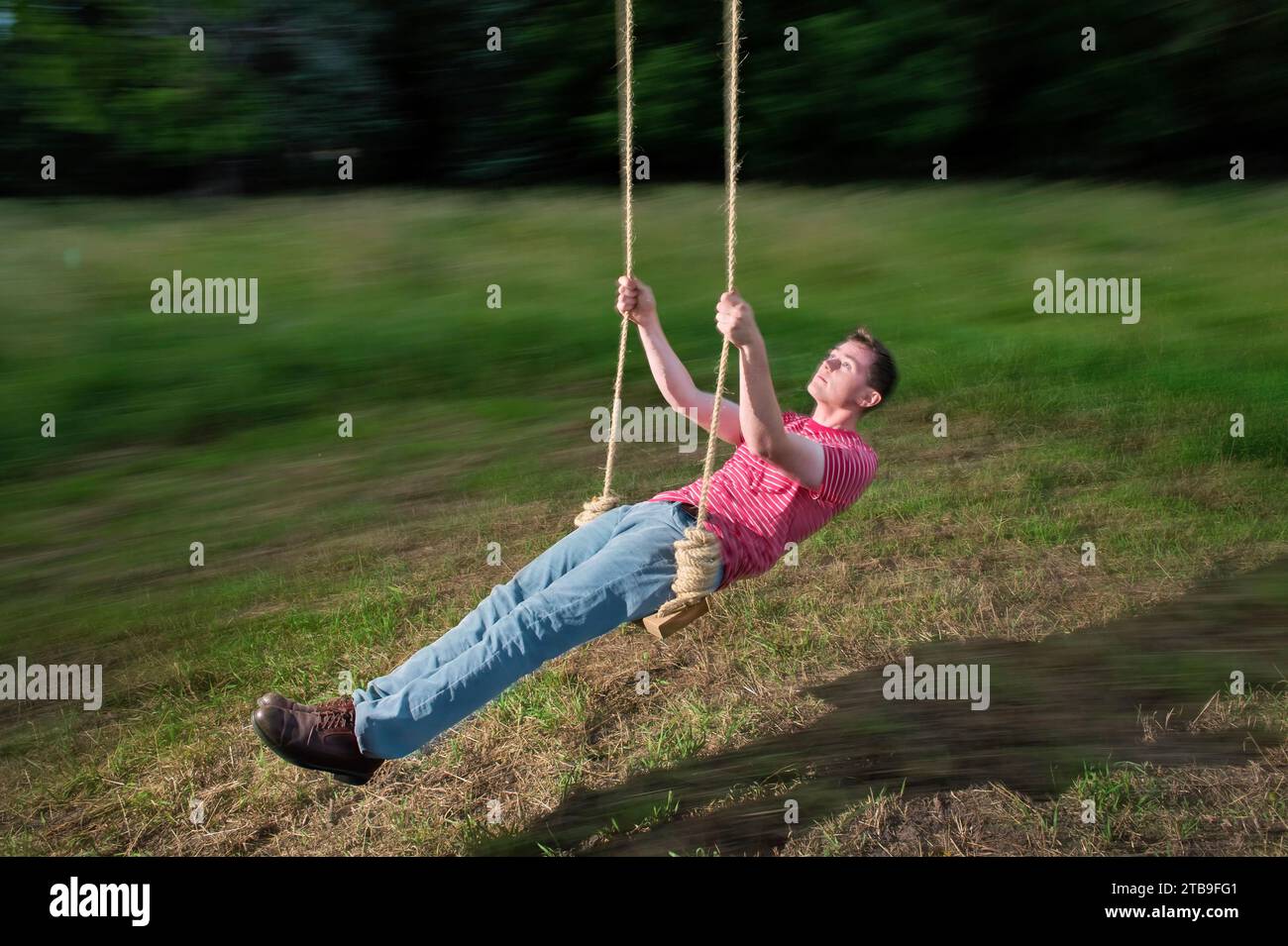 Young man is shown during a slow shutter on a rope swing; Bennet, Nebraska, United States of America Stock Photo