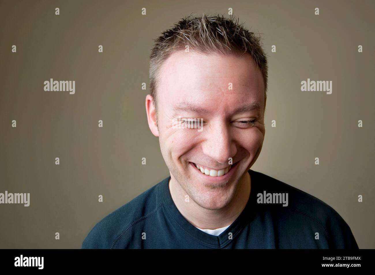 Portrait of a young man laughing; Studio Stock Photo