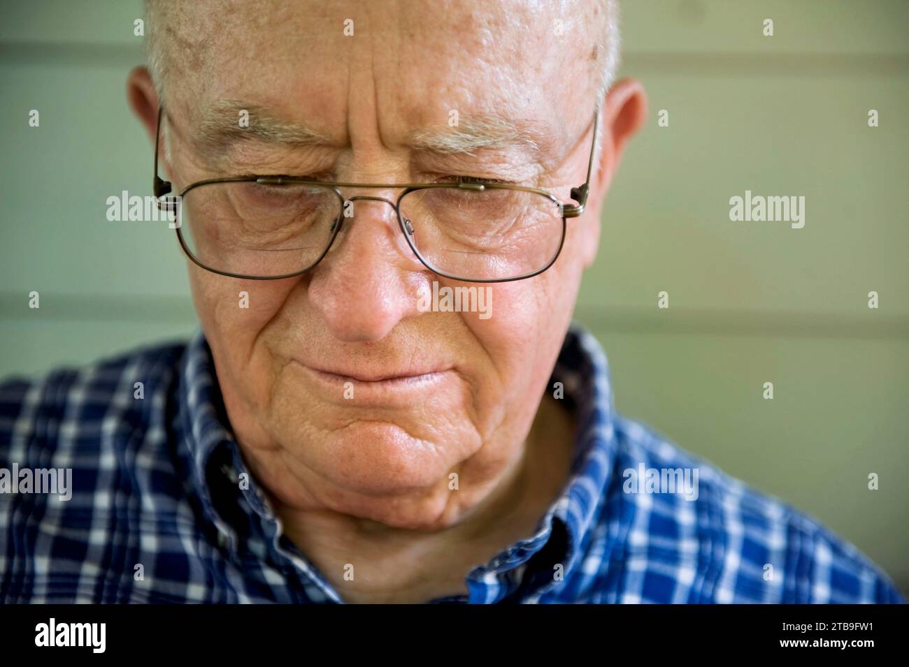 Portrait of an elderly man with eyeglasses looking down; Elkhorn, Nebraska, United States of America Stock Photo