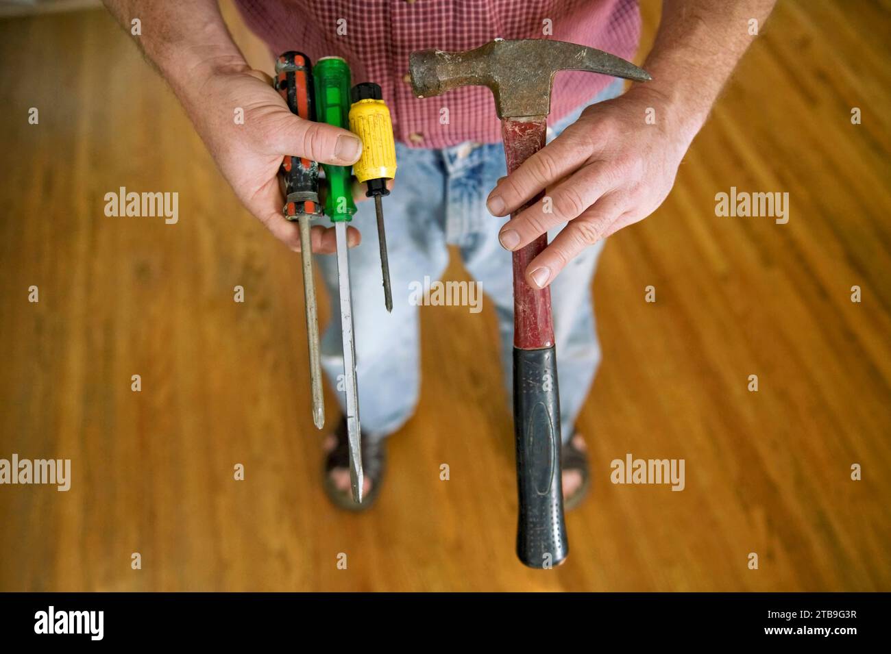 Close up of a man's hands holding various tools; Lincoln, Nebraska, United States of America Stock Photo