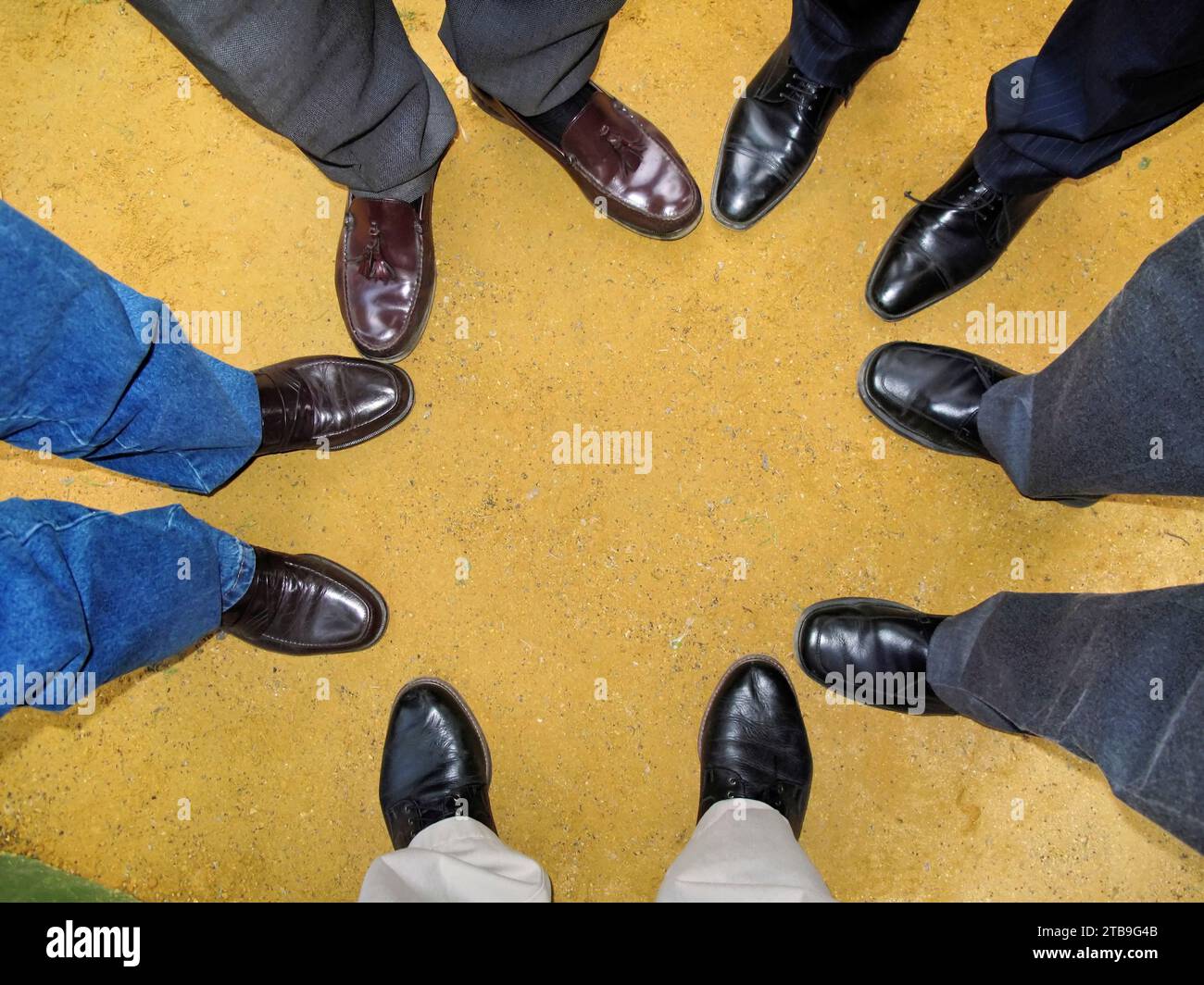 Men wearing dress shoes stand in a circle; Madrid, Spain Stock Photo
