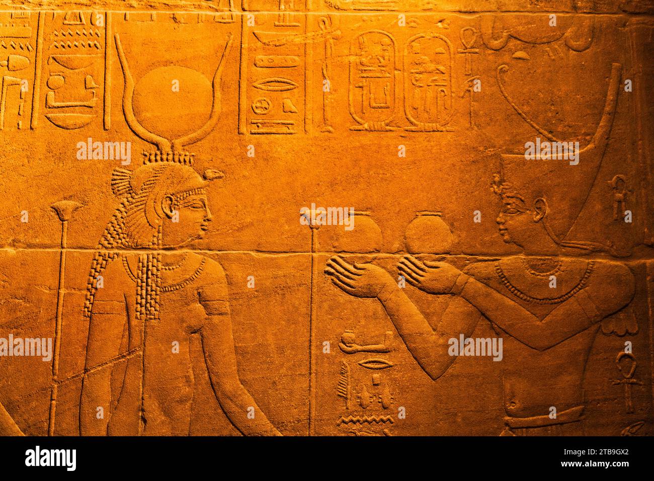 Close-up of bas-relief of hieroglyphs and the Goddess Isis inside the Temple of Isis at Philae Island in the Nile River with golden light Stock Photo