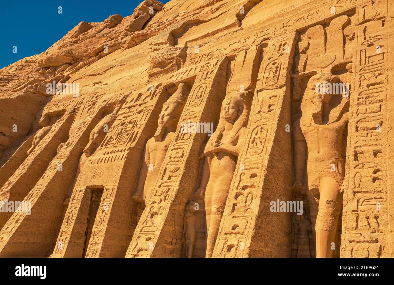 The six standing colossal statues honoring Hathor the Goddess of Music and Love and Ramses II's wife, Nefertari in front of the Temple of Hathor at... Stock Photo