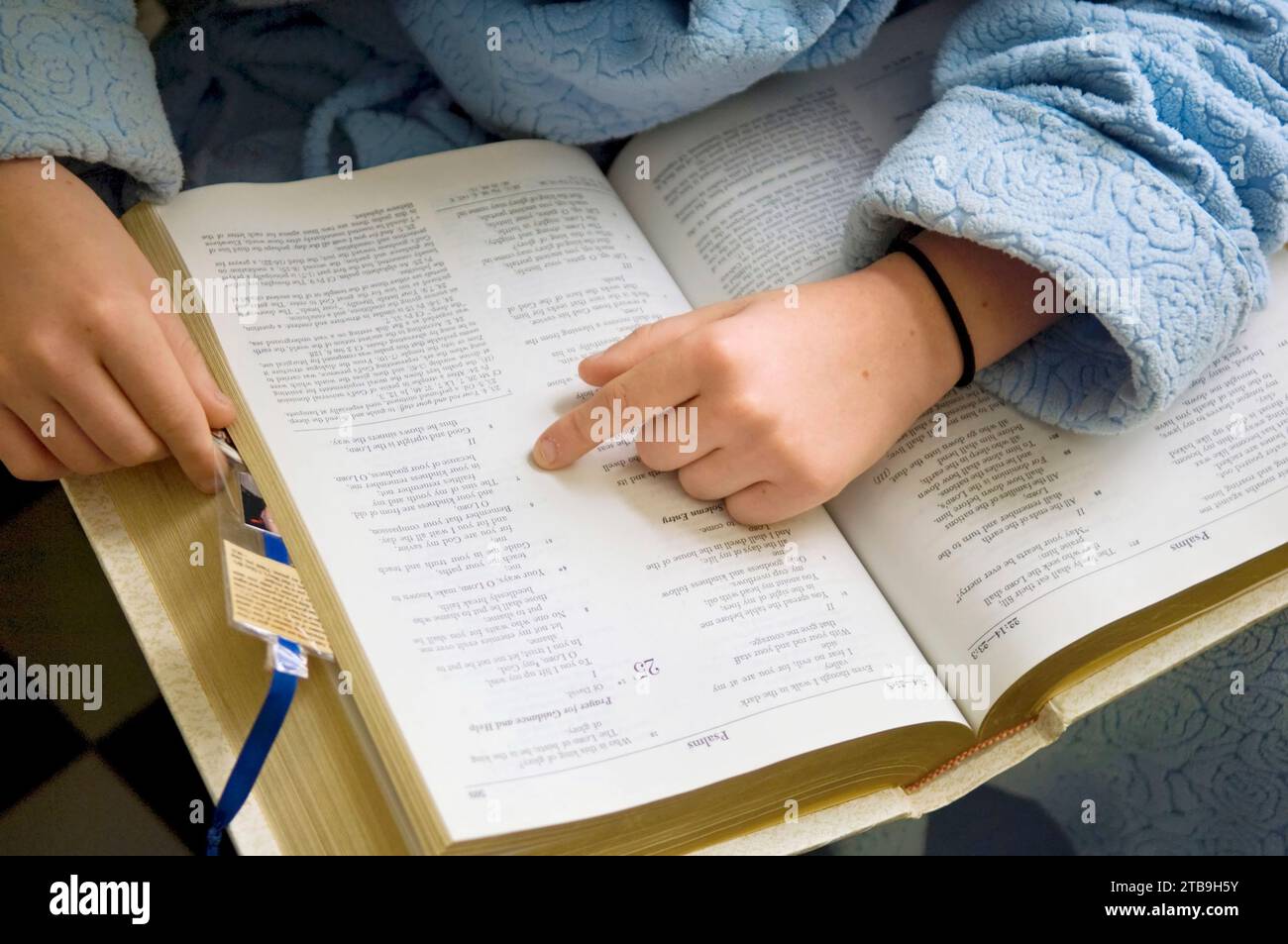 Close-up of a young girl reading the Bible; Lincoln, Nebraska, United States of America Stock Photo