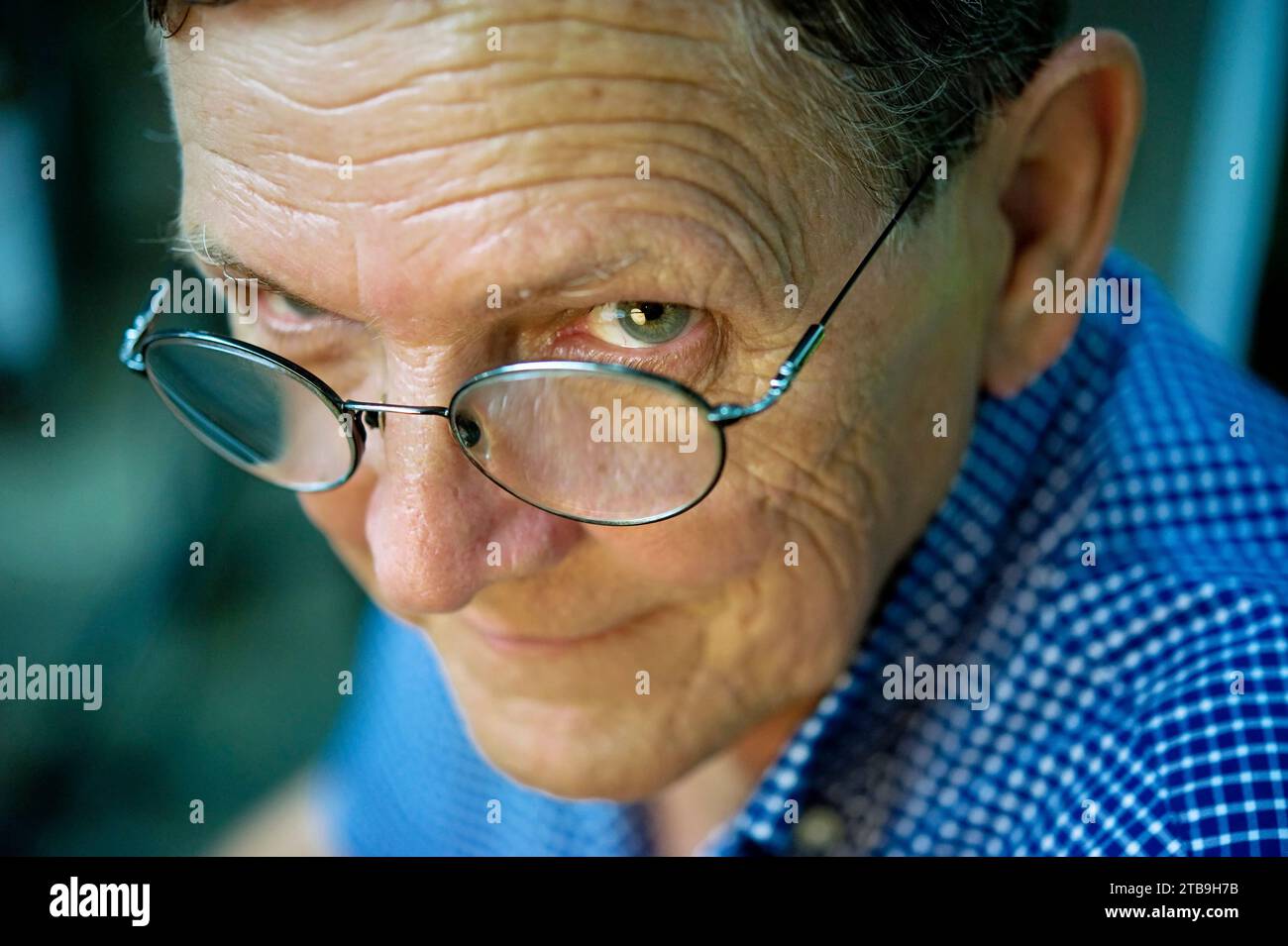 Close-up portrait of a man wearing eyeglasses, looking up at the camera; Houston,Texas, United States of America Stock Photo