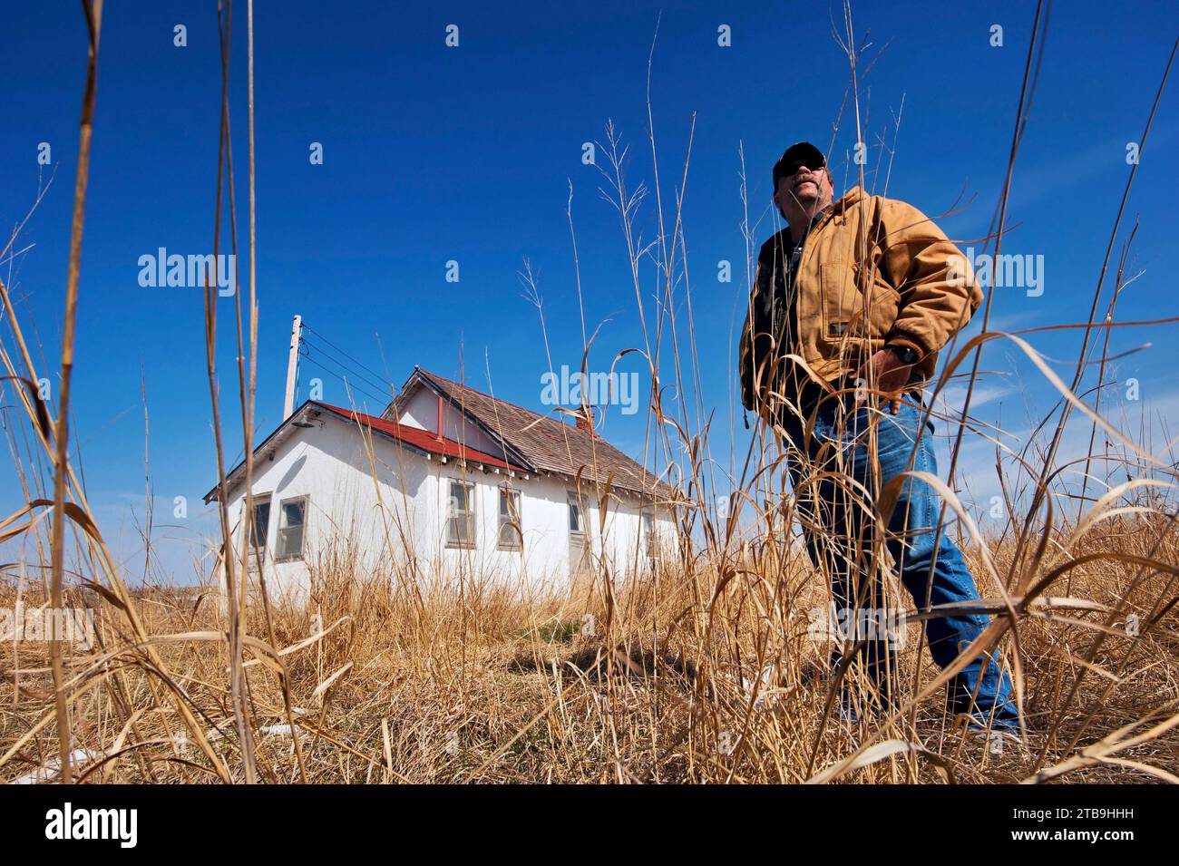 Man explores an abandoned one-room schoolhouse in the Nebraska Sandhills, USA; Sandhills, Nebraska, United States of America Stock Photo