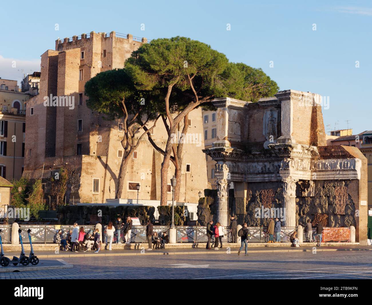 Ancient buildings with Stone Pines and pedestrians in front on an autumn evening in the city of Rome, Lazio Region, Italy, December 05, 2023 Stock Photo