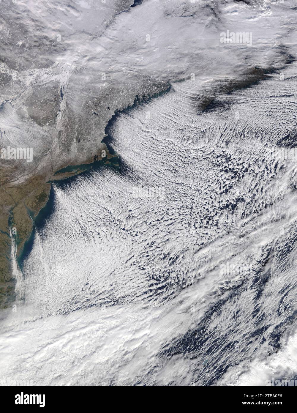 Satellite view of the frozen Northeast landscape with cloud streets blowing over the Atlantic Ocean. Stock Photo