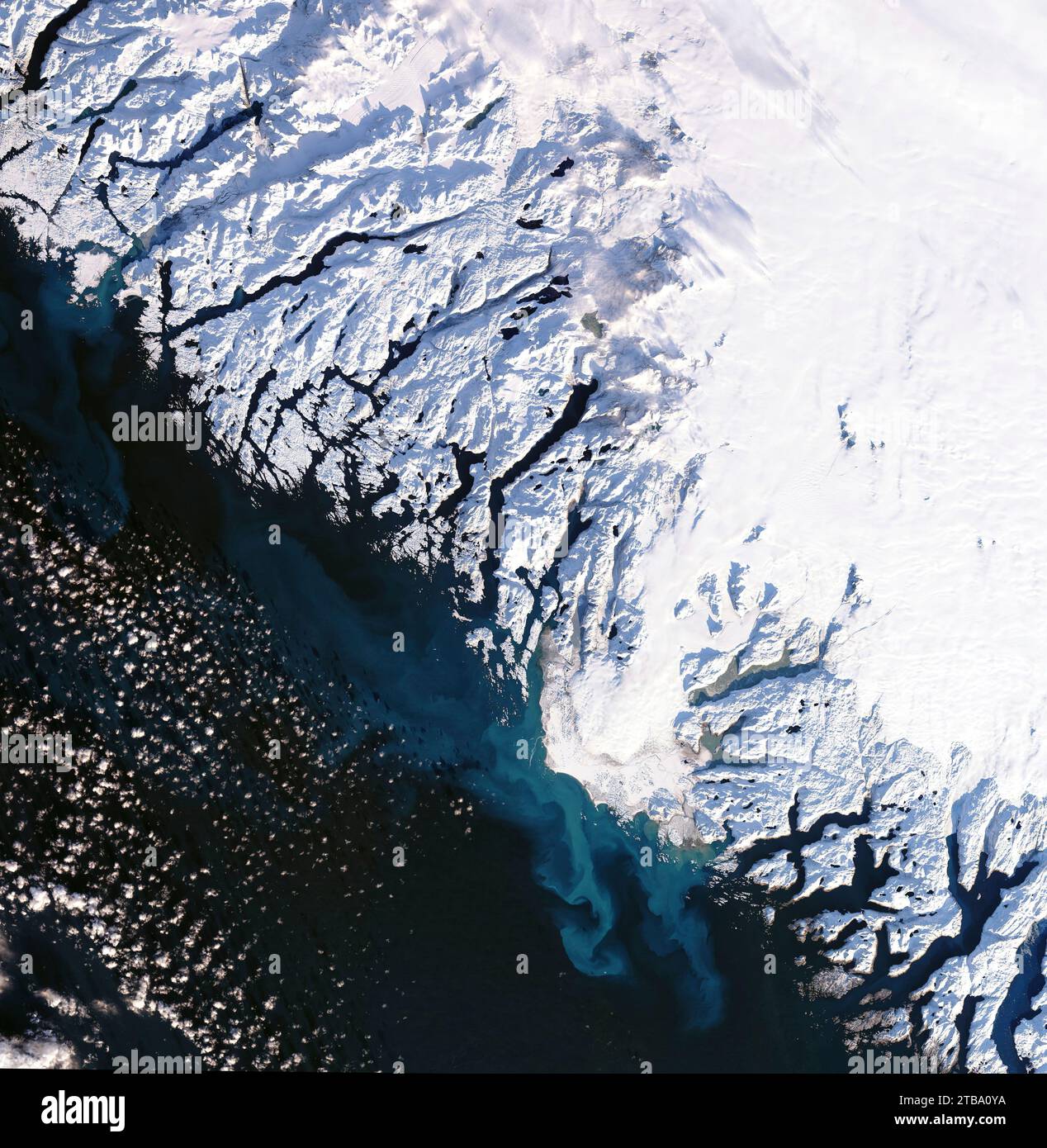 Glacial meltwater draining from Frederikshaab Isblink and mixing with the darker waters of the Labrador Sea. Stock Photo