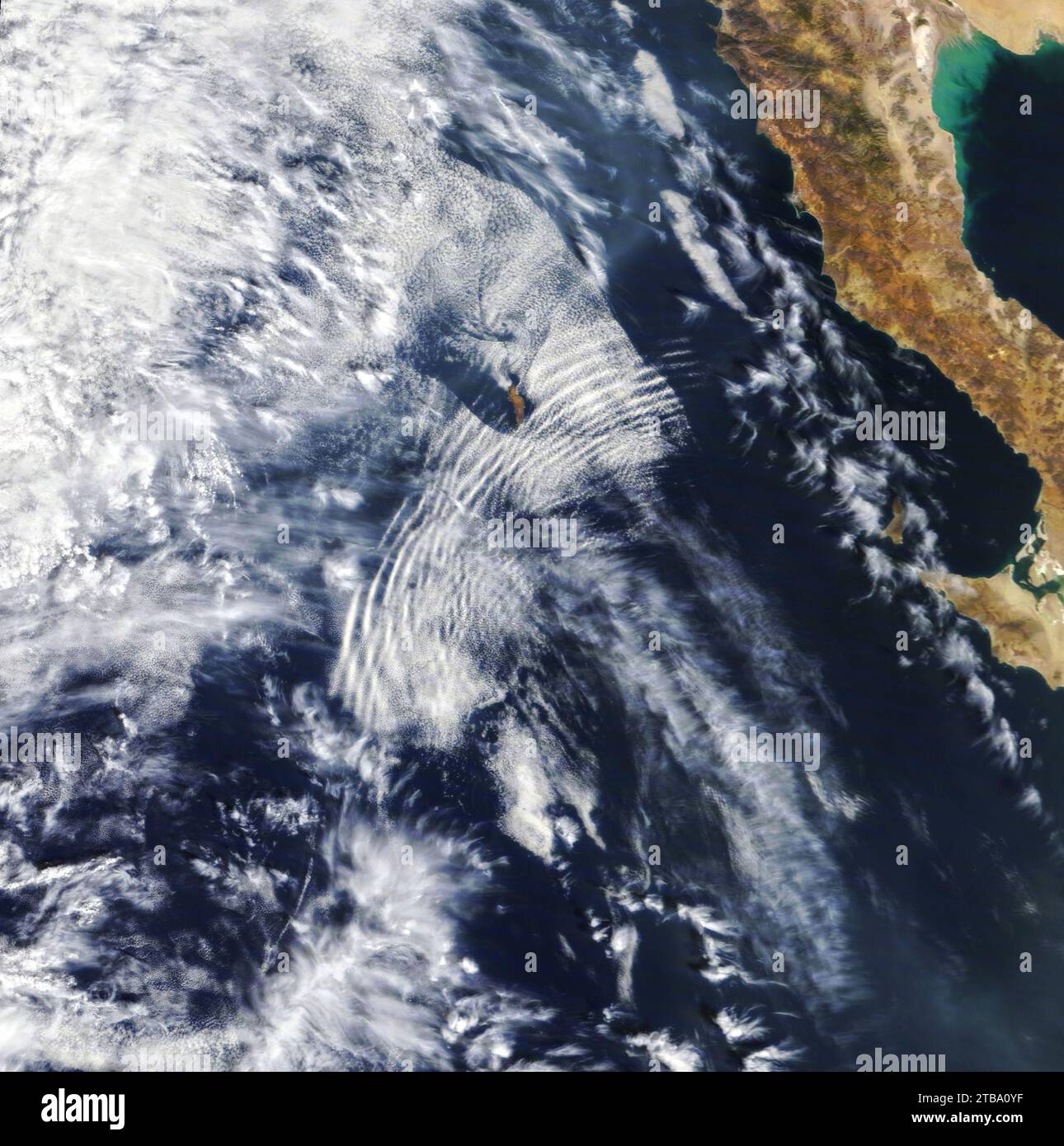 Satellite view of a series of undulating cloud bands rippled over the Pacific Ocean near Baja California. Stock Photo
