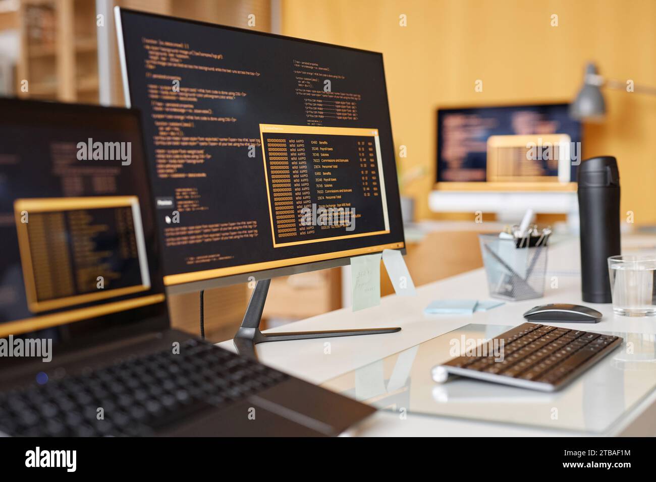 Close up background image of computer screen with colored code lines at workplace in IT development office, copy space Stock Photo