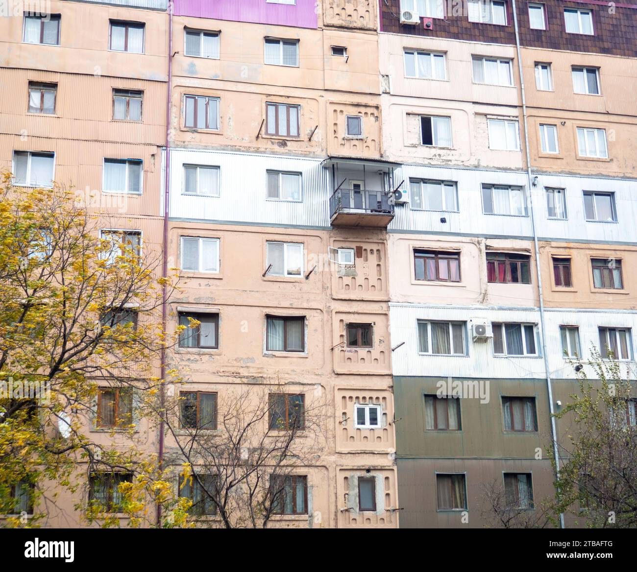 Old nine-story building. High-rise building in Asia. This is how the locals live. Unrenovated, scary, old building facade. Background from windows Stock Photo