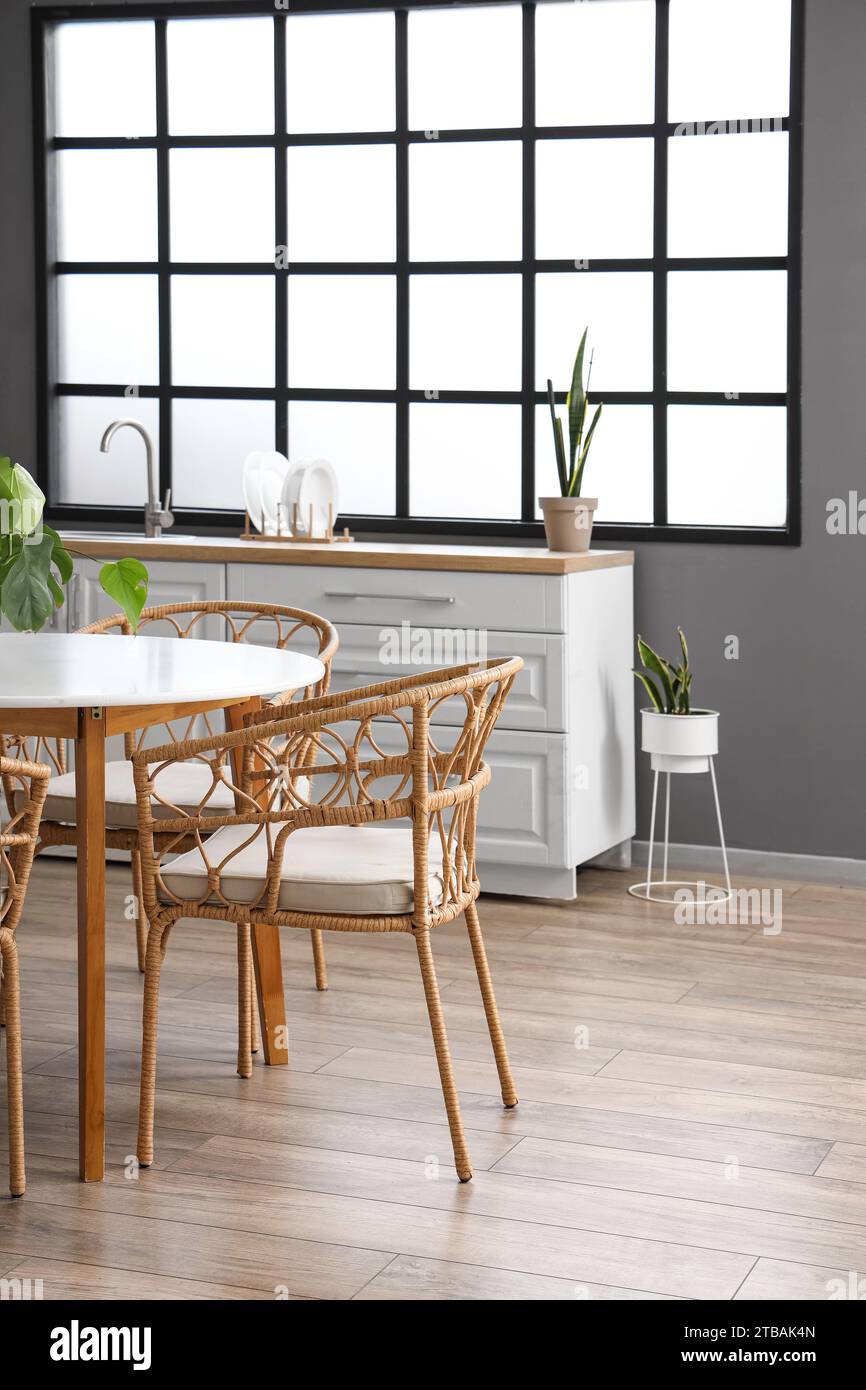 Interior of modern kitchen with dining table and white counters Stock ...