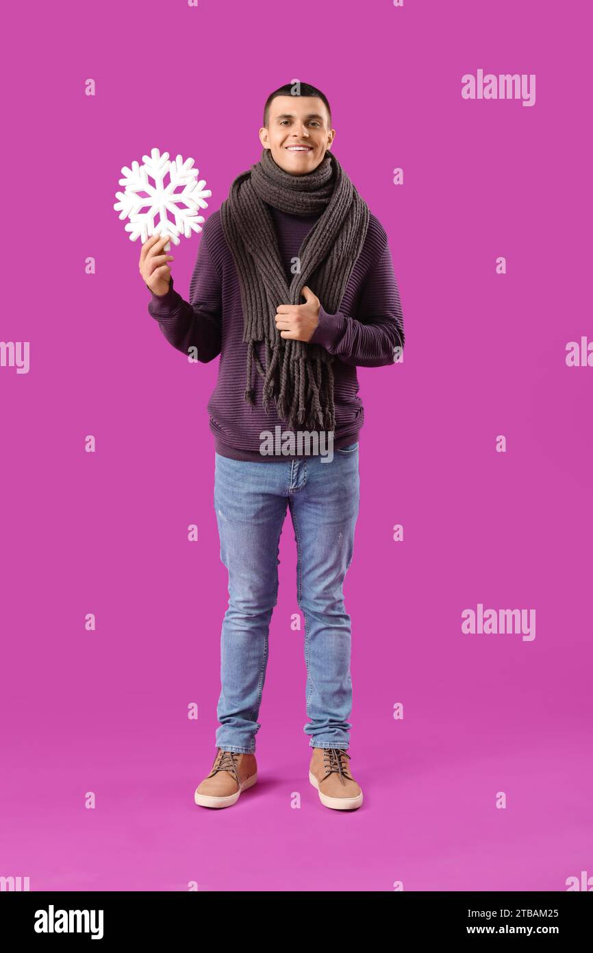 Young man in winter clothes with snowflake on purple background Stock ...