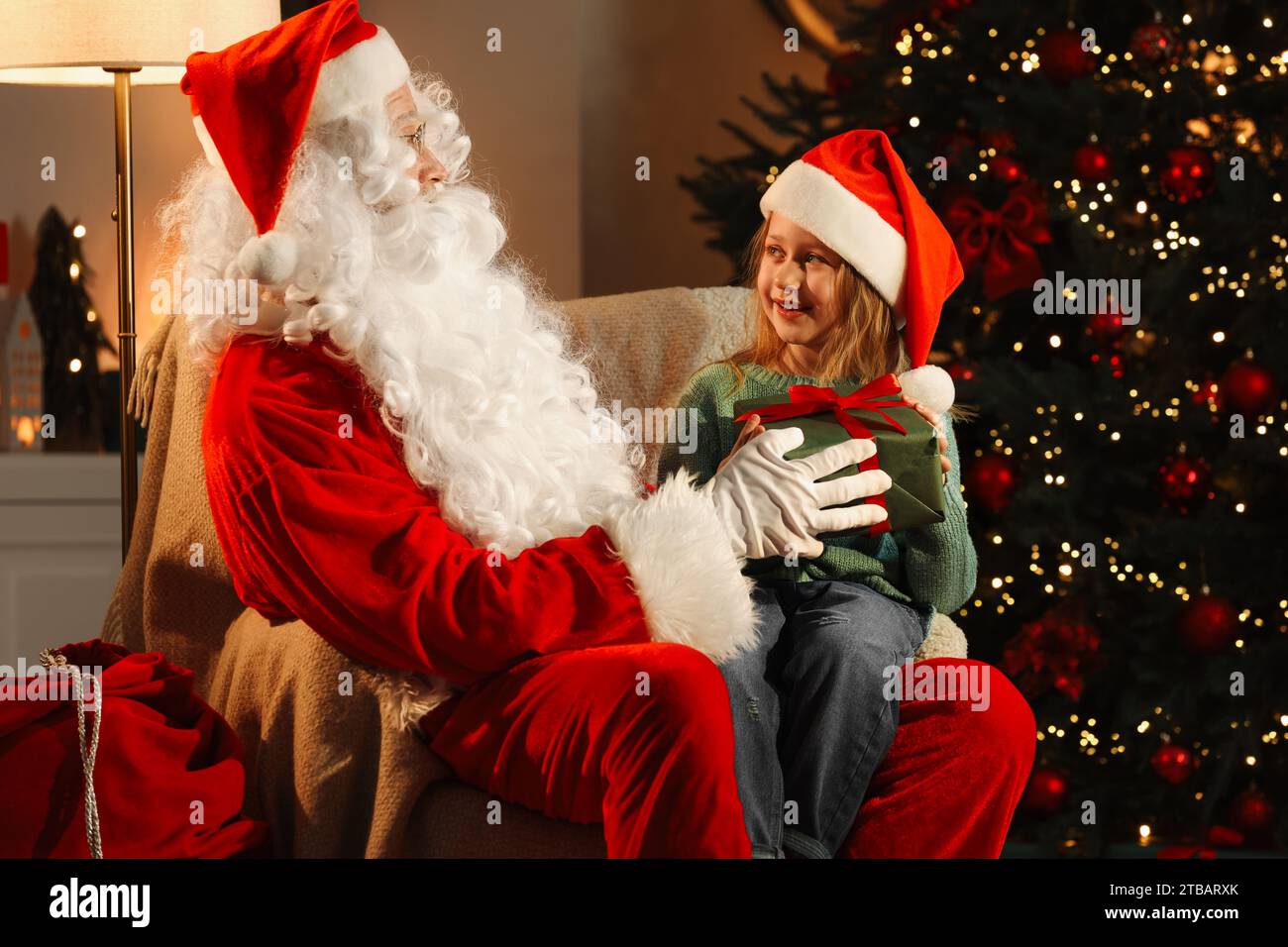 Merry Christmas. Santa Claus giving gift to little girl in room Stock ...