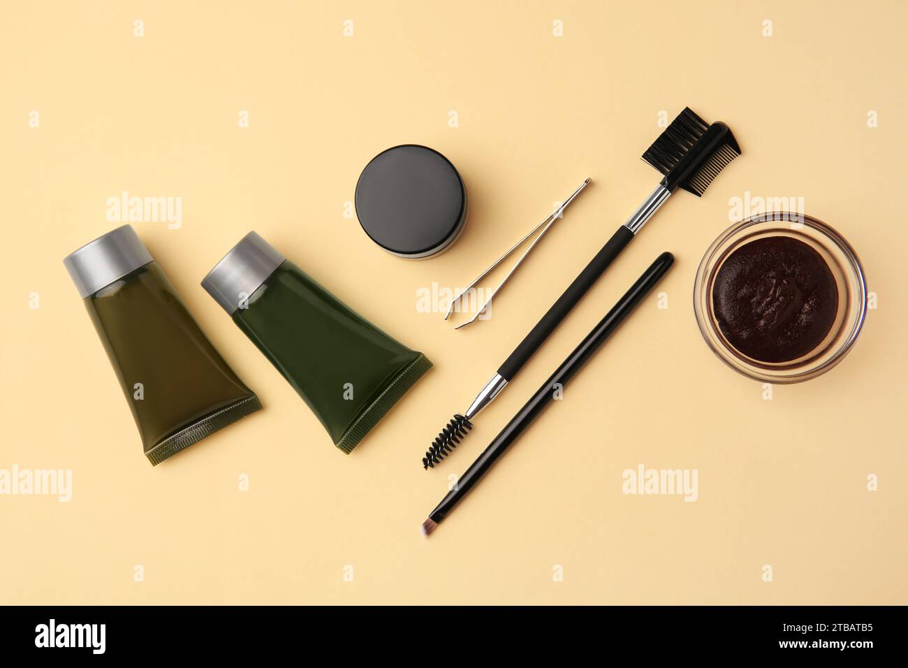 Flat lay composition with eyebrow henna and tools on beige background Stock Photo