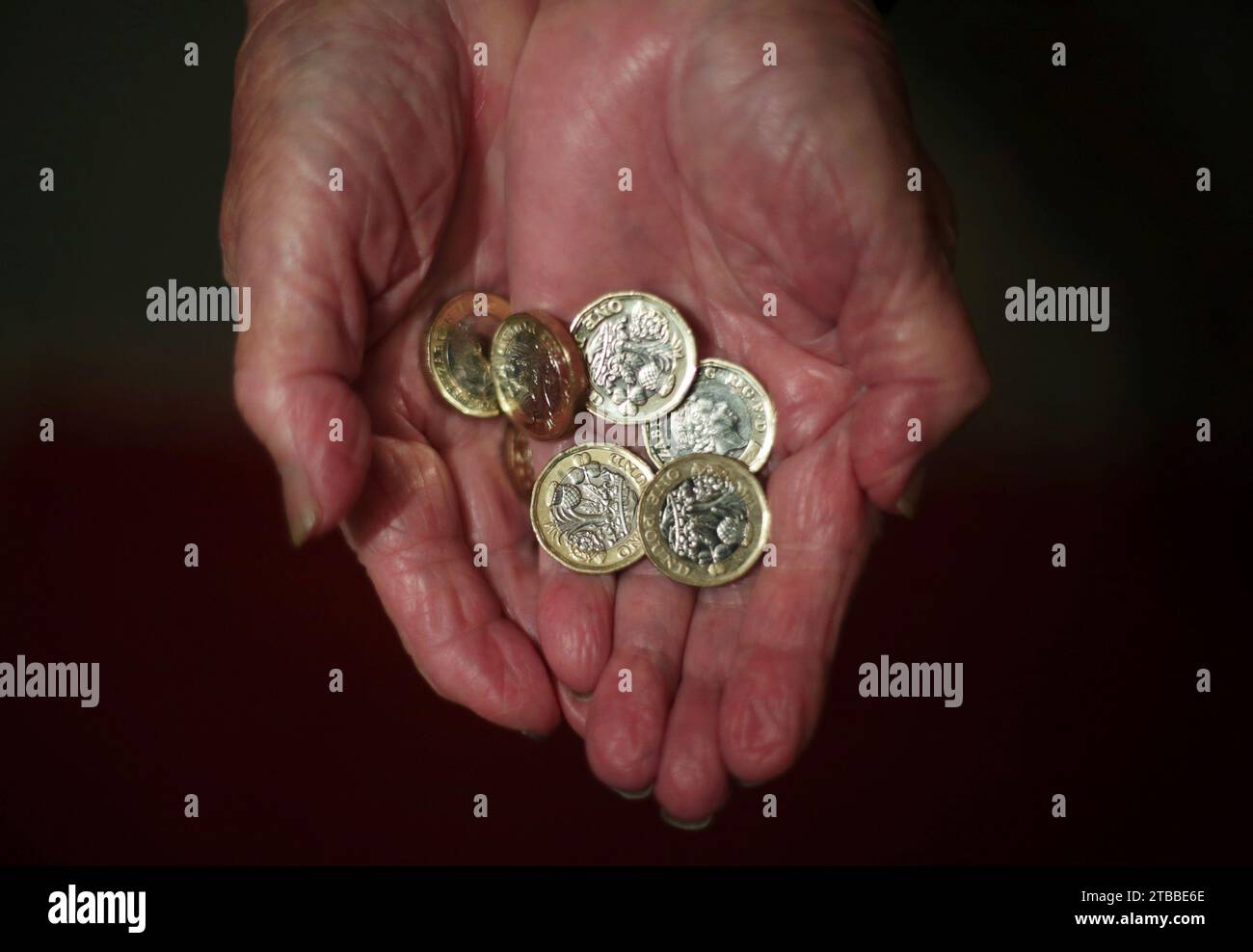 File photo dated 21/12/17 of an elderly woman holding pound coins in her hands. More than 200,000 pensioners have been left out of pocket by a total of £1.3 billion and some £8.2 billion has been overpaid in benefits in the past financial year, according to a watchdog's annual report. The level of fraud and error in benefit spending 'remains unacceptably high', the Public Accounts Committee (PAC) said, as it raised its concerns that the Department of Work and Pensions (DWP) does not expect this to return to pre-pandemic levels until 2027-28. Issue date: Wednesday December 6, 2023. Stock Photo