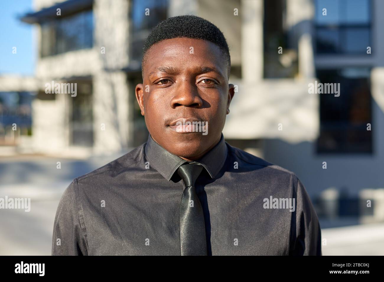 Portrait of young Black businessman, wearing black shirt and tie Stock Photo