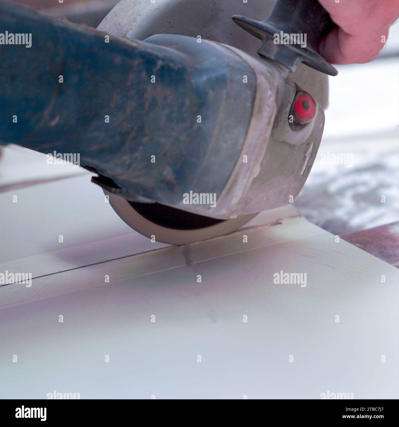 A construction worker saws ceramic tiles using an angle grinder Stock Photo