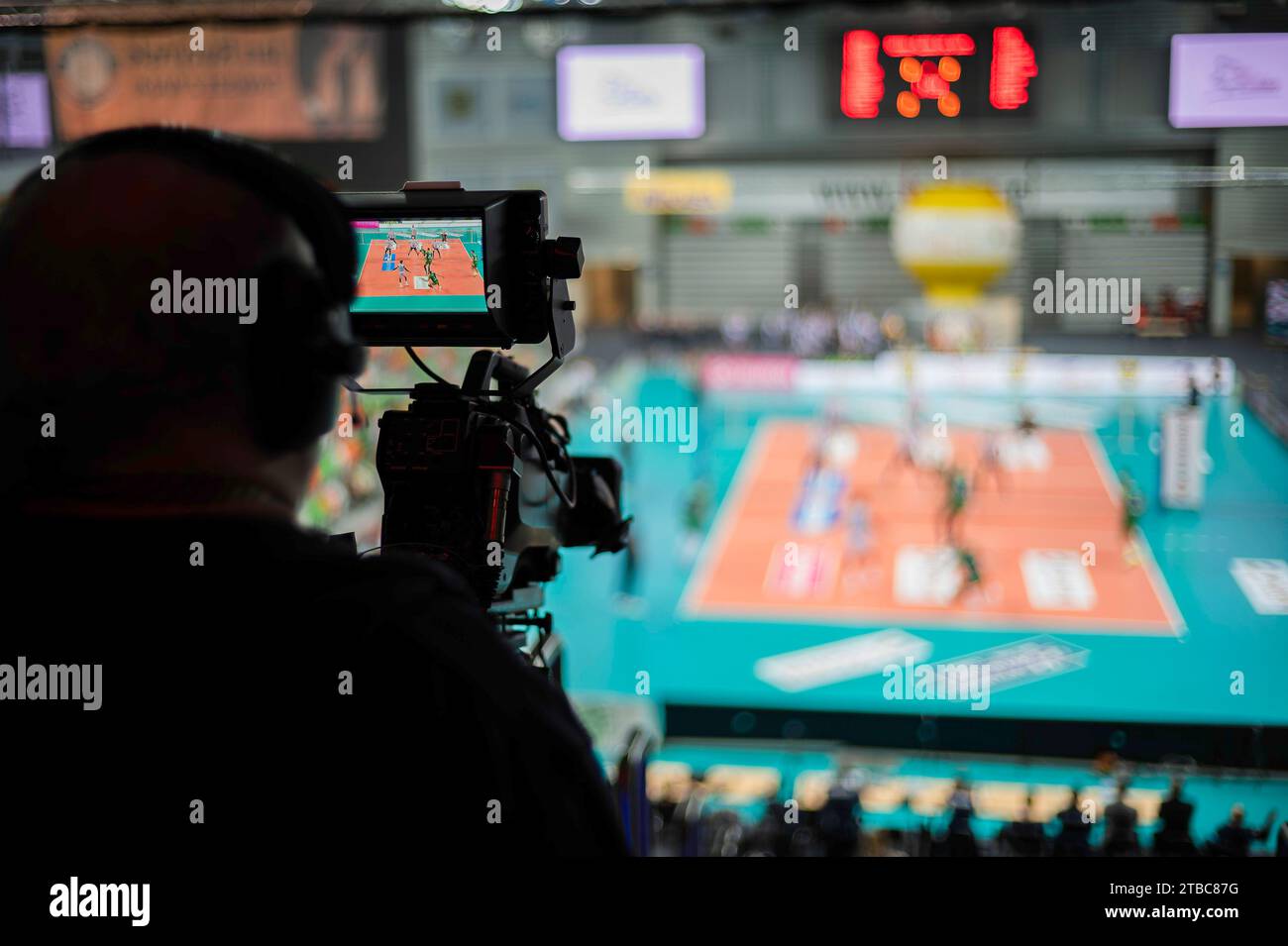 Professional TV camera in sports hall during volleyball match. Stock Photo