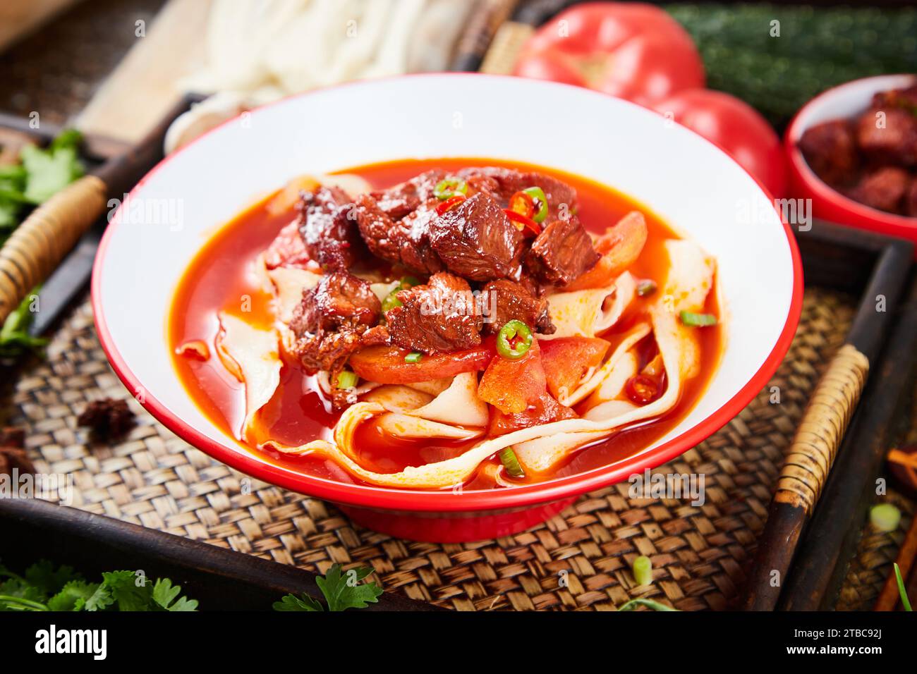 Spicy red soup beef noodle in a bowl on a white background, biang biang noodles Stock Photo