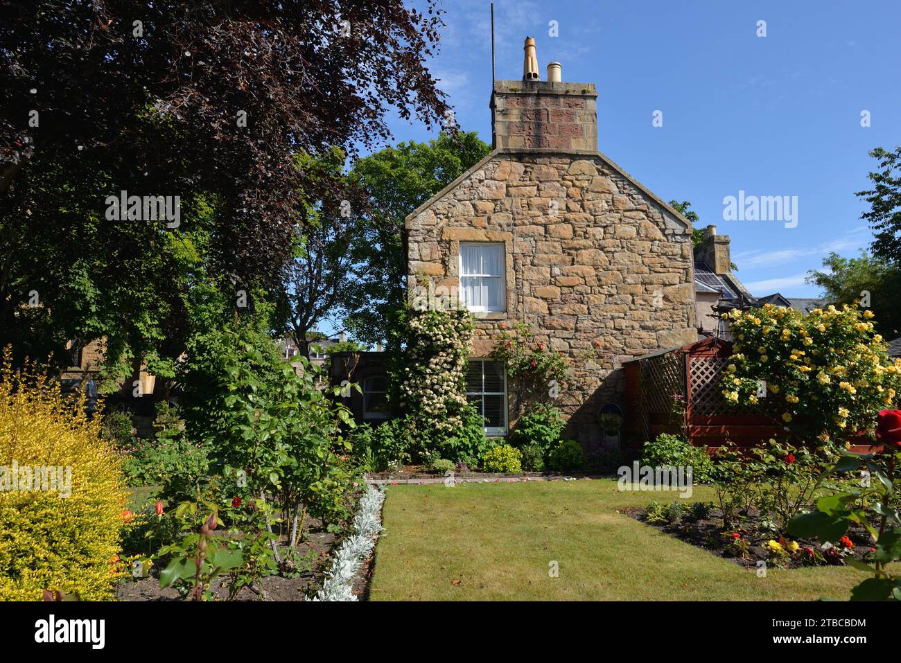 Gable end of a traditional stone house with garden in Sutherland, Scotland Stock Photo