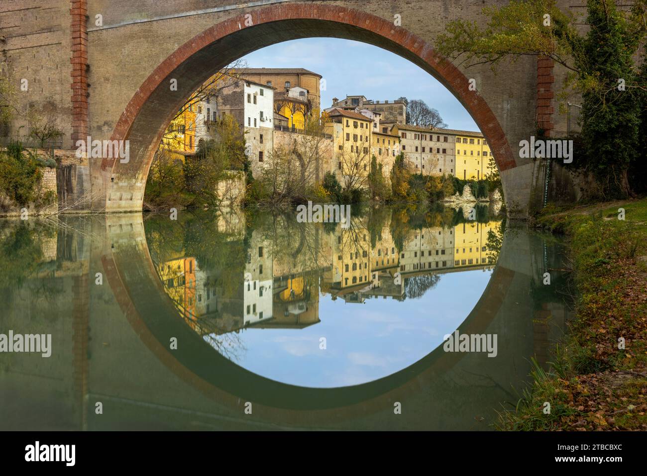A view of Fossombrone's charming old town from the park, with the Ponte della Concordia spanning the Metauro River. Stock Photo