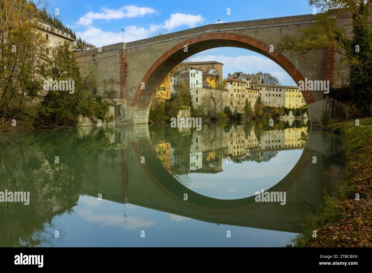 A view of Fossombrone's charming old town from the park, with the Ponte della Concordia spanning the Metauro River. Stock Photo