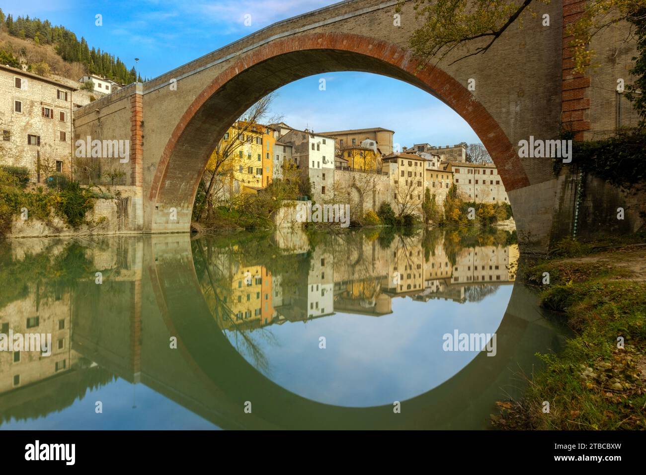 A view of Fossombrone's charming old town from the park, with the Ponte della Concordia spanning the Metauro River. Stock Photo
